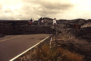 Photo of a lava flow covering a road.